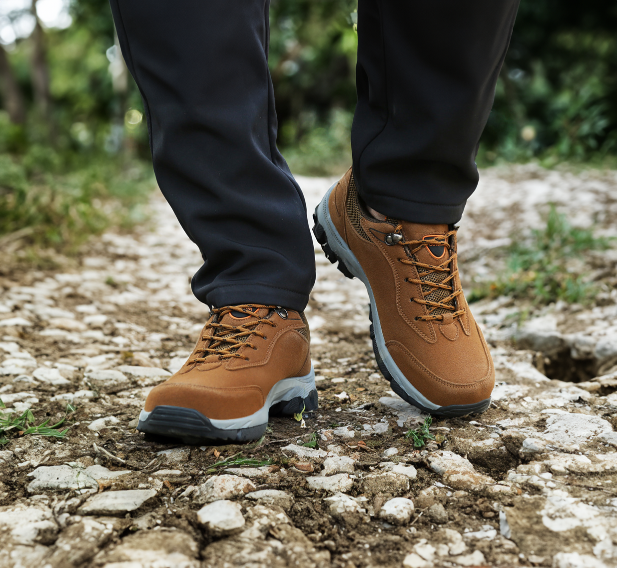 Brown hiking boots on rocky trail, showcasing durable outdoor footwear. Perfect for trekking, adventure, and rugged terrain exploration.