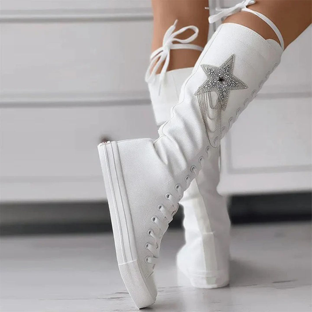 White knee-high wedge sneakers with star embellishment, lace-up design, and platform sole. Stylish women's footwear for casual and trendy outfits.