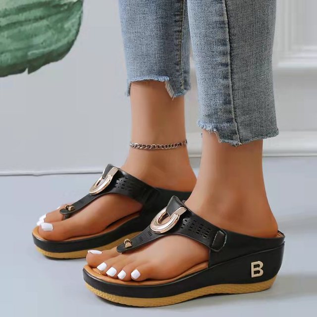 Women's black wedge sandals with open toe design, gold buckle detail, and comfortable sole. Perfect for summer beachwear and casual outings.