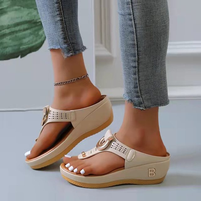 Women's beige wedge sandals with open toe design, featuring a stylish buckle and perforated details. Perfect for summer beachwear and casual outings.