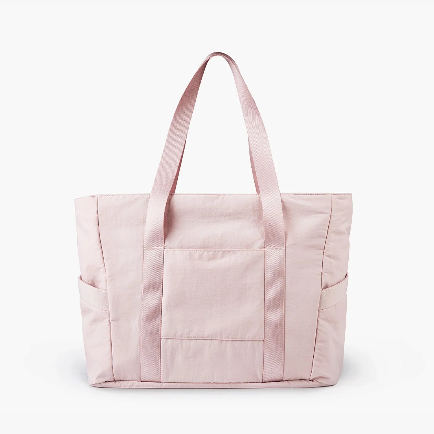 Light pink tote bag with front pocket and side compartments, featuring durable straps. Ideal for everyday use. Stylish and practical accessory.