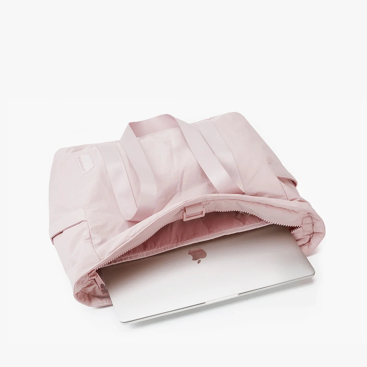 Pink tote bag with laptop compartment, featuring a partially visible silver MacBook. Ideal for stylish tech-savvy professionals.