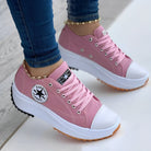 Pink platform sneakers with white toe caps and laces, featuring a star logo on the side. Fashionable casual footwear for women.