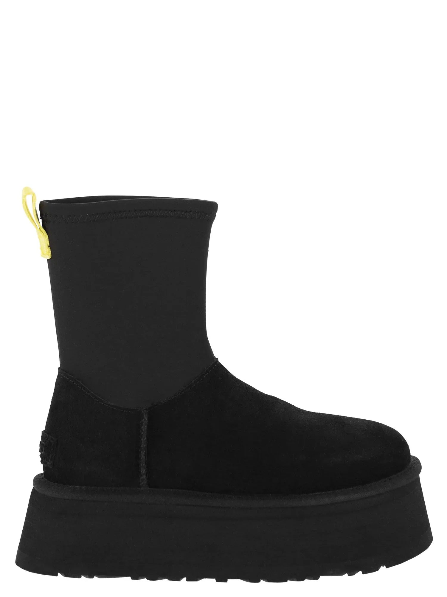 Black platform ankle boot with yellow pull tab, suede upper, and chunky sole. Trendy women's footwear, stylish fall fashion boot.