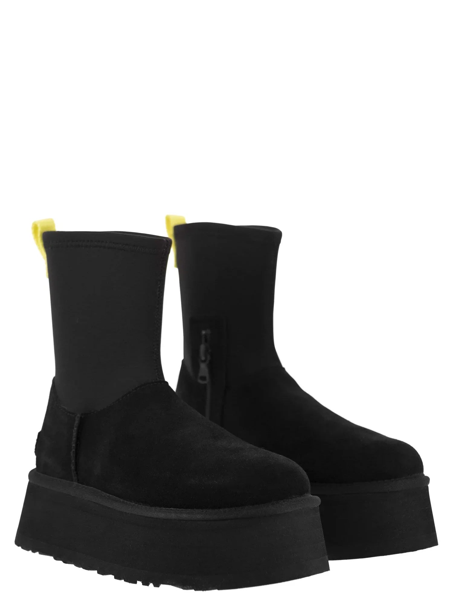 Black platform ankle boots with yellow pull tabs, featuring a side zipper and chunky sole. Stylish women's footwear, perfect for fashion-forward looks.