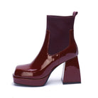 Glossy burgundy platform ankle boot with square toe and chunky heel, featuring a ribbed sock-like upper. Fashionable women's footwear.