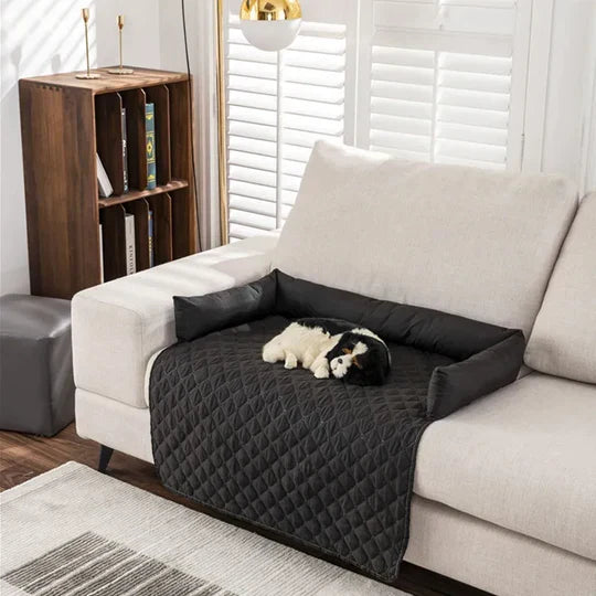 Dog sleeping on a black quilted sofa protector cover, beige couch, modern living room, pet furniture cover, home decor, cozy pet-friendly space.