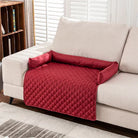 Red quilted sofa protector on beige couch, featuring armrest covers and a diamond pattern. Ideal for pet owners and home decor enthusiasts.