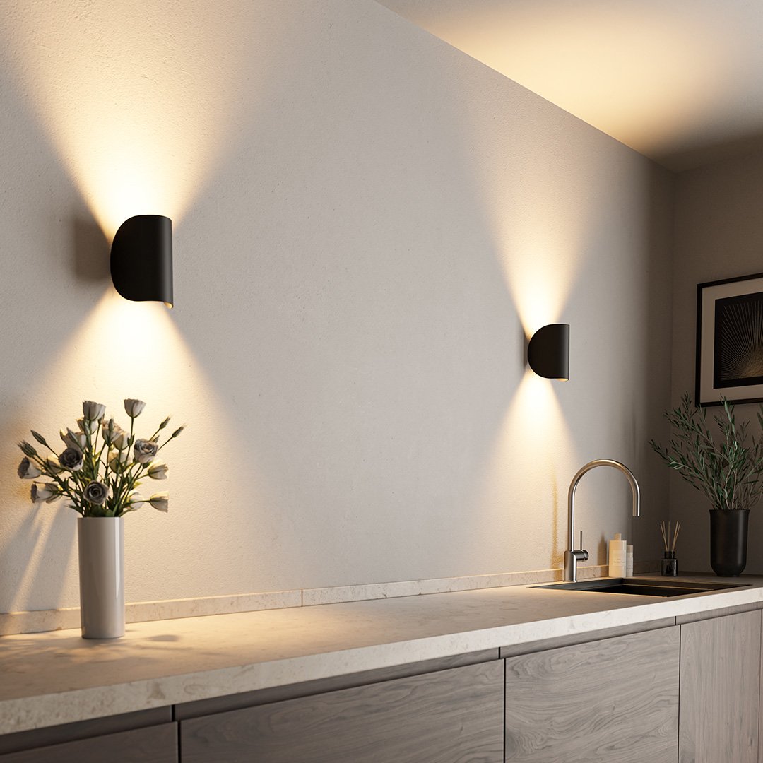 Modern kitchen with sleek black wall sconces, minimalist design, gray cabinets, and elegant decor. Ideal for contemporary home lighting inspiration.