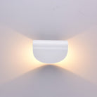 Modern white wall sconce with minimalist design, emitting warm ambient light. Ideal for contemporary home decor and interior lighting solutions.