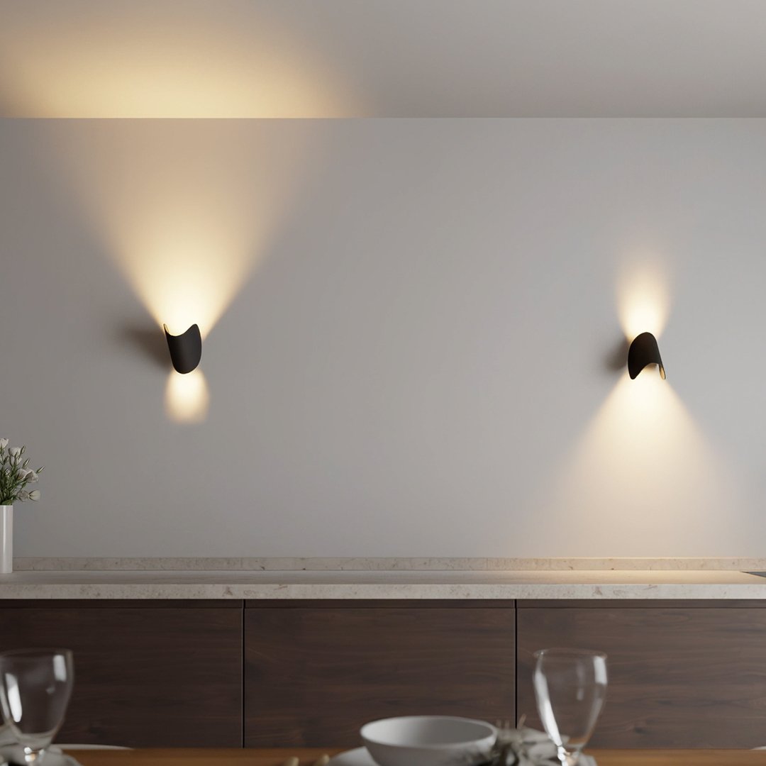 Modern wall sconces illuminating a minimalist dining room with wooden cabinetry and elegant table setting; contemporary home lighting design.