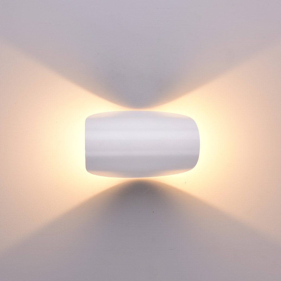 Modern white wall sconce with soft ambient lighting, minimalist design, home decor, energy-efficient LED light fixture, contemporary interior lighting.