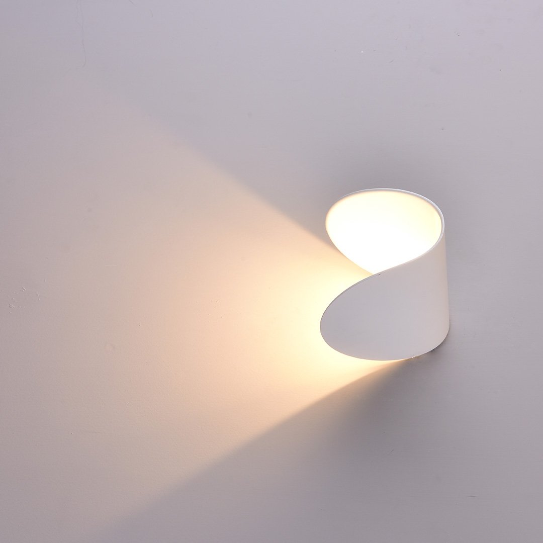 Modern white wall sconce with minimalist design, casting soft ambient light. Ideal for contemporary home decor and interior lighting solutions.