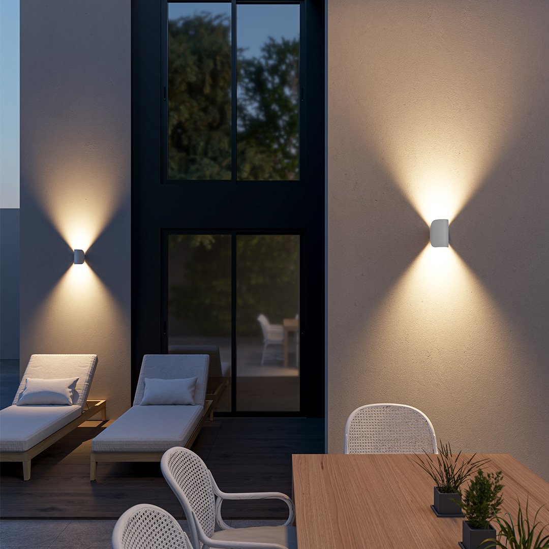 Modern outdoor patio with sleek wall lights, wooden table, and cushioned lounge chairs. Contemporary exterior design, evening ambiance.