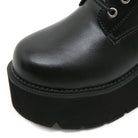 Black leather platform boot with thick sole, close-up view. Stylish footwear, durable design, perfect for fashion-forward individuals seeking comfort.