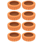 Eight orange tire planters with textured tread pattern, arranged in two columns. Ideal for garden decor, upcycled tire planters, eco-friendly gardening.