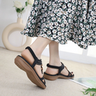 Floral dress with black strappy sandals, featuring studded details and cushioned soles, perfect for summer fashion and casual wear.