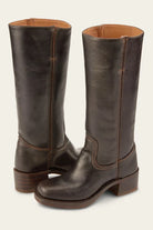 Brown leather knee-high boots with stacked heel, featuring detailed stitching. Stylish women's footwear, perfect for fall fashion and outdoor wear.