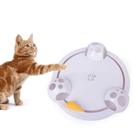 Orange tabby cat playing with interactive circular cat toy featuring moving parts and a yellow feather. Perfect for pet entertainment and exercise.