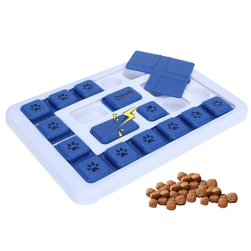 Dog puzzle toy with blue sliding tiles on a white base, featuring paw prints and a bone symbol, alongside a pile of kibble. Interactive pet feeder.