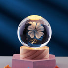 Crystal ball with illuminated four-leaf clover design on wooden base, decorative glass sphere, unique home decor, lucky charm ornament.