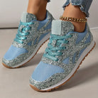 Stylish blue glitter sneakers with mesh detailing and gum soles, paired with a gold anklet and ripped jeans. Trendy women's fashion footwear.