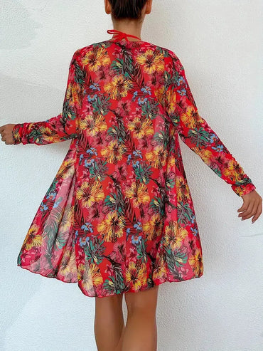 Woman wearing a vibrant floral print red dress with long sleeves, showcasing a flowy design. Perfect for summer fashion and casual outings.