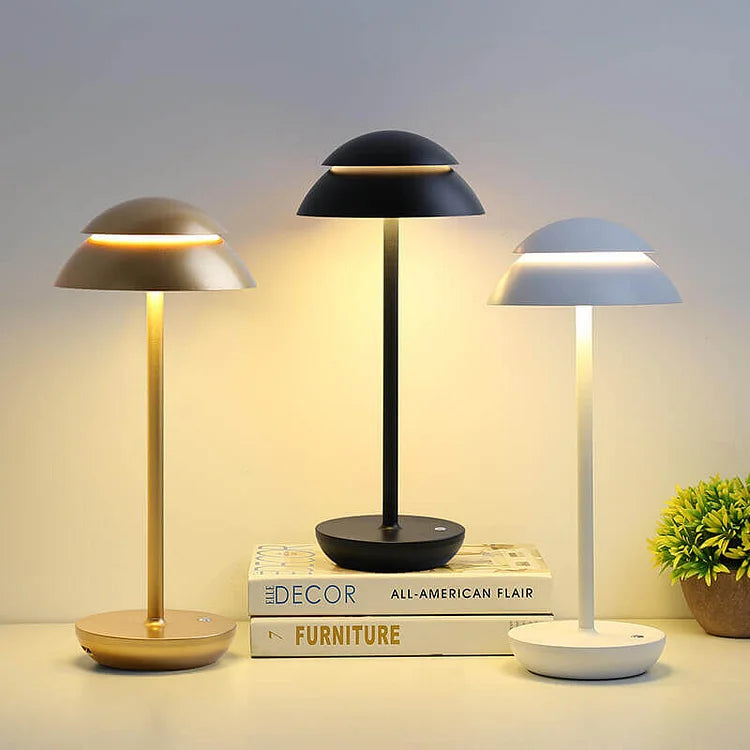 Modern LED table lamps in gold, black, and white on a stack of decor books, ideal for stylish home lighting and interior design inspiration.