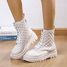 White quilted patent leather combat boots with chunky soles on wooden floor; stylish women's footwear, trendy fashion boots, lace-up design.