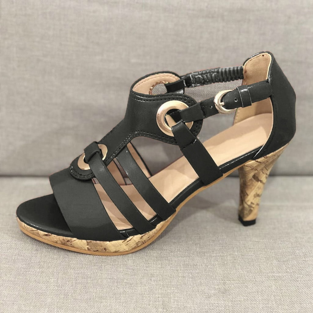 Black strappy high heel sandal with cork heel, featuring circular buckle accents. Perfect for summer fashion, women's footwear, stylish sandals.