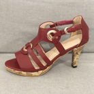 Red strappy high heel sandal with cork heel, featuring circular buckle accents, perfect for summer fashion. Women's footwear, stylish and elegant design.