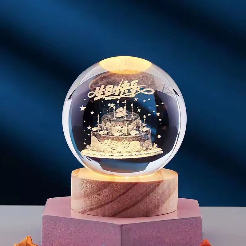 Illuminated crystal ball with intricate 3D cake and star design, set on a wooden base. Perfect for home decor, gifts, and ambient lighting.