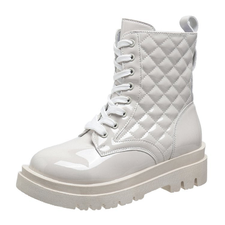 White patent leather combat boot with quilted design, chunky sole, and lace-up front. Stylish women's footwear, trendy fashion boot.