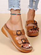 Women's tan leather sandals with double buckle straps, cushioned sole, and casual design. Perfect for summer fashion and comfortable walking.