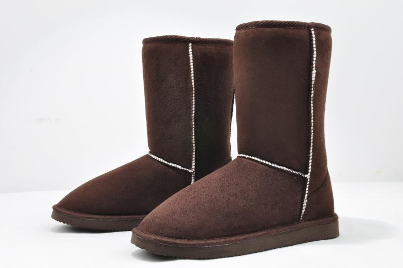 Brown suede winter boots with white stitching, featuring a mid-calf design and flat soles, perfect for cold weather. Cozy, stylish footwear for women.