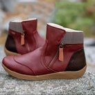 Women's red leather ankle boots with side zipper, brown heel, and cushioned sole, perfect for casual wear. Stylish, comfortable footwear.