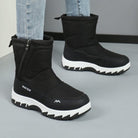 Black winter boots with thick white soles, side zippers, and "Winter" branding, worn with light blue jeans. Ideal for cold weather fashion.