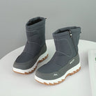 Gray winter snow boots with thick white soles and side zippers on a white surface. Ideal for cold weather, offering warmth and traction.