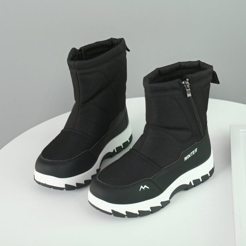 Black winter boots with thick white soles, side zippers, and "Winter" branding, designed for warmth and comfort. Ideal for cold weather fashion.