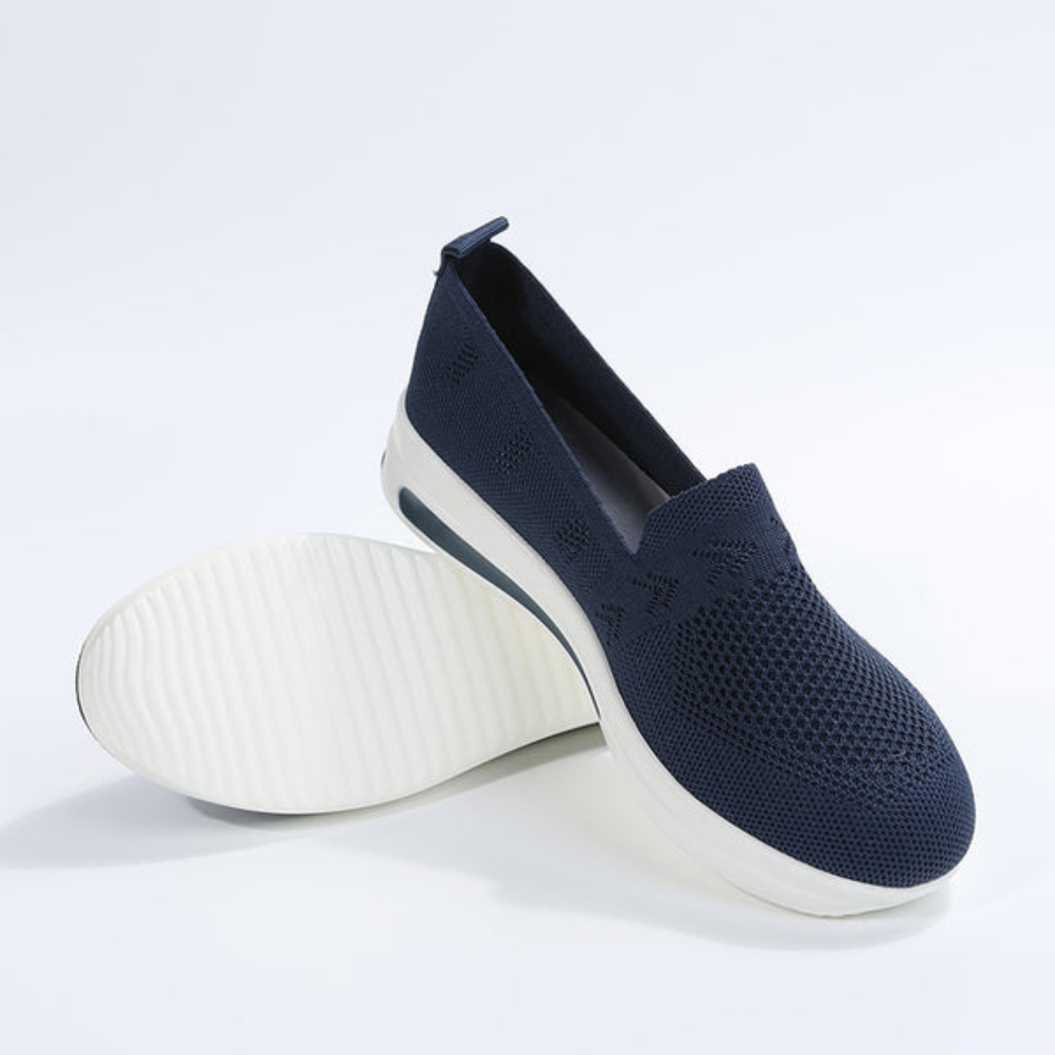 Navy blue slip-on sneakers with breathable mesh upper and white non-slip sole, perfect for casual wear. Lightweight, comfortable footwear for men and women.