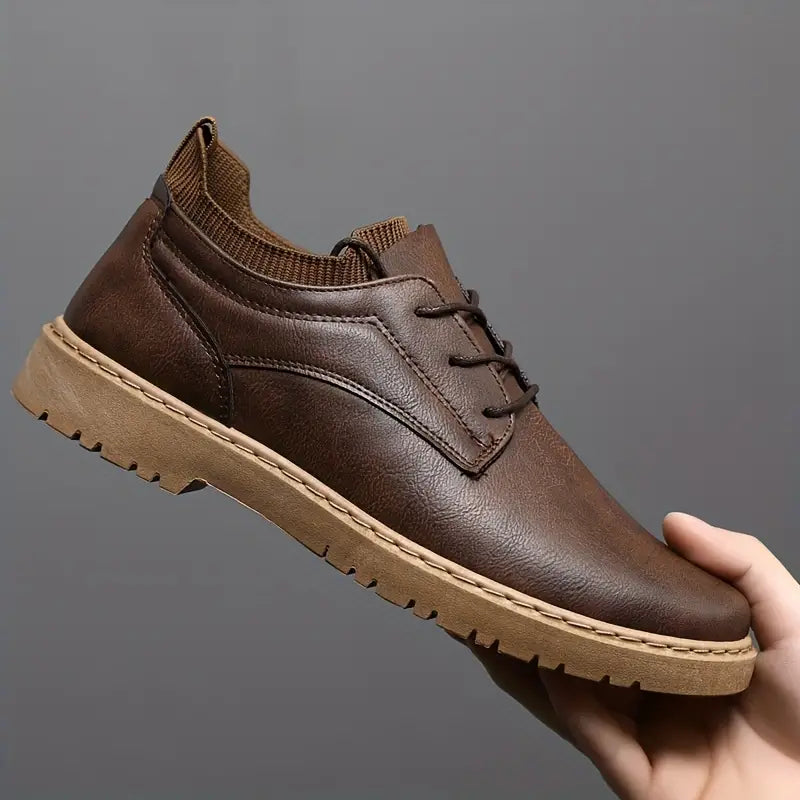 Brown leather casual shoe with lace-up design, rubber sole, and ankle-high knit collar, ideal for men's fashion and comfortable everyday wear.