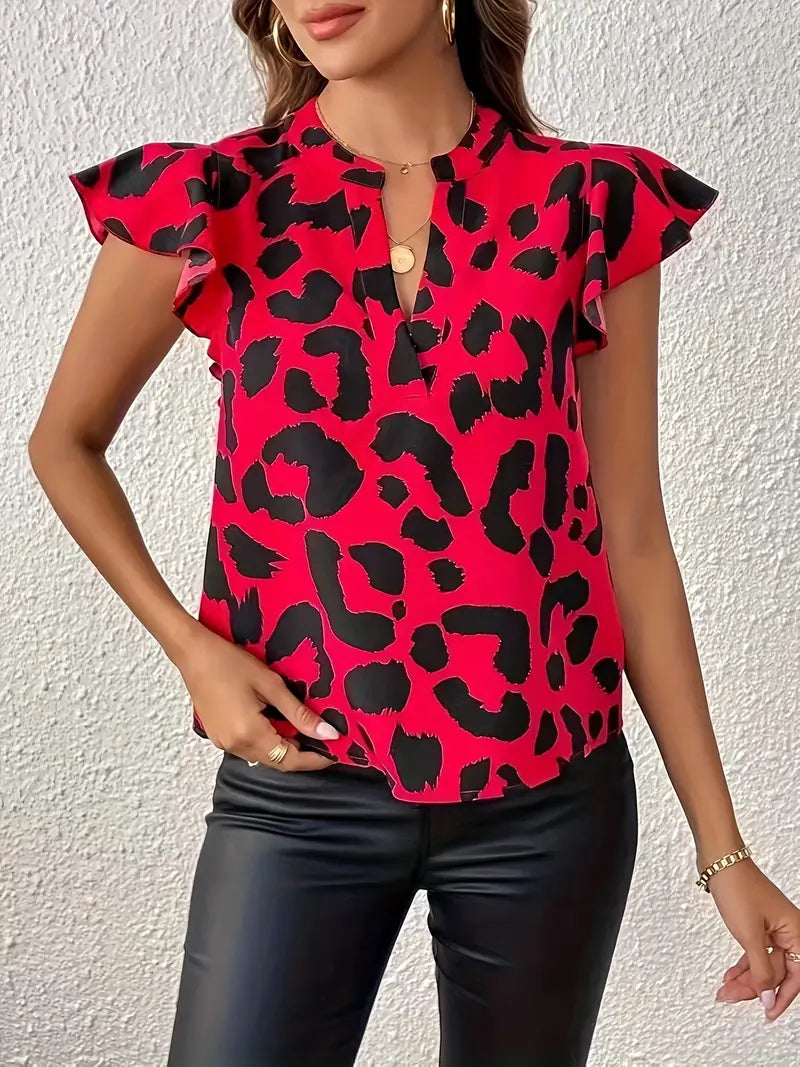 Woman wearing a red and black leopard print blouse with flutter sleeves, paired with black leather pants. Fashionable outfit for casual or evening wear.