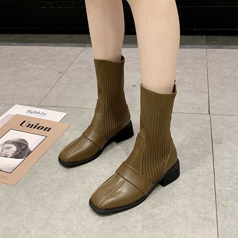 Brown leather ankle boots with ribbed knit socks, block heels, and white stitching detail on gray tile floor. Fashionable women's footwear.