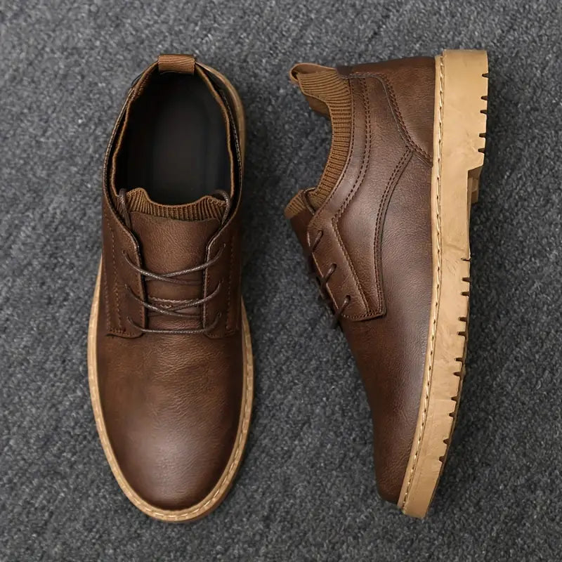 Men's brown leather casual shoes with lace-up design, rubber sole, and textured finish on gray carpet. Stylish footwear for everyday wear.