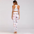 Woman wearing floral print activewear set, featuring a racerback sports bra and high-waisted leggings, perfect for yoga or gym workouts.