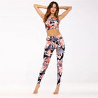 Woman wearing a purple floral sports set, featuring a sleeveless crop top and high-waisted leggings, perfect for yoga or fitness activities.