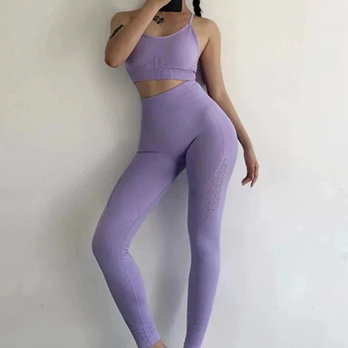Woman in lavender sportswear set with decorative back stripes, featuring a crop top and high-waisted leggings. Fitness fashion, activewear style.