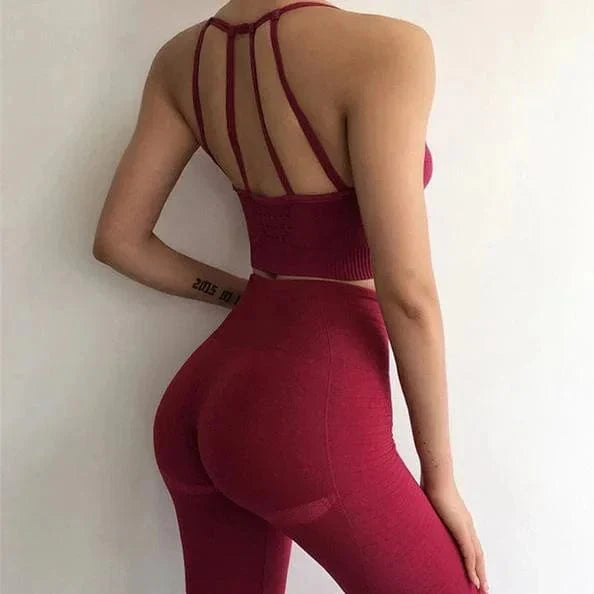 Woman in red athletic wear with decorative back straps, showcasing fitness fashion. Ideal for yoga, gym, or active lifestyle enthusiasts.
