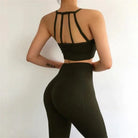 Woman wearing black sports set with decorative back stripes, showcasing fitness fashion. Ideal for yoga, gym workouts, and active lifestyle.