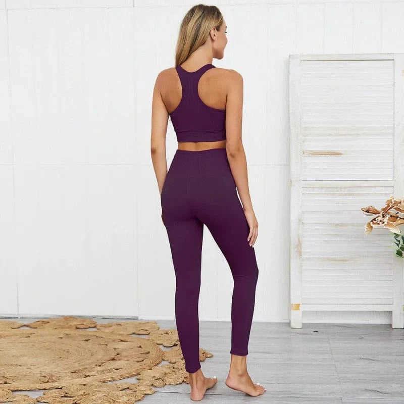 Woman in purple yoga set, back view, standing on a rug in a minimalist room. Activewear, fitness fashion, workout clothing, comfortable leggings.